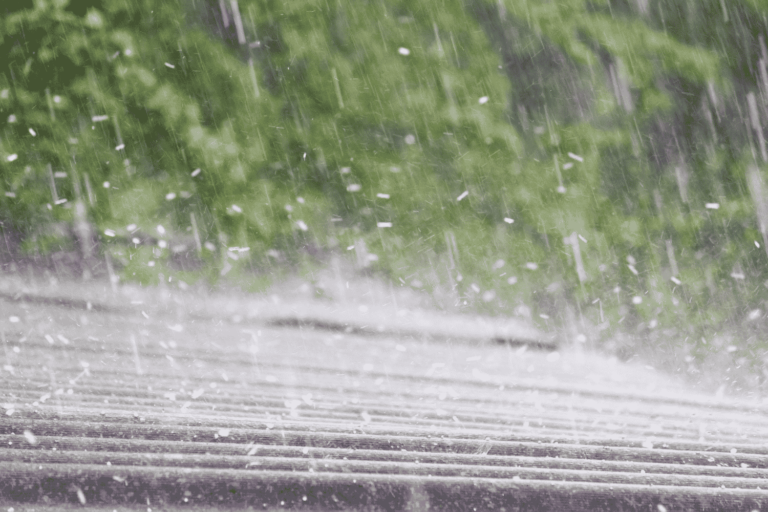 A person documenting hail damage on a roof, preparing to file an insurance claim.