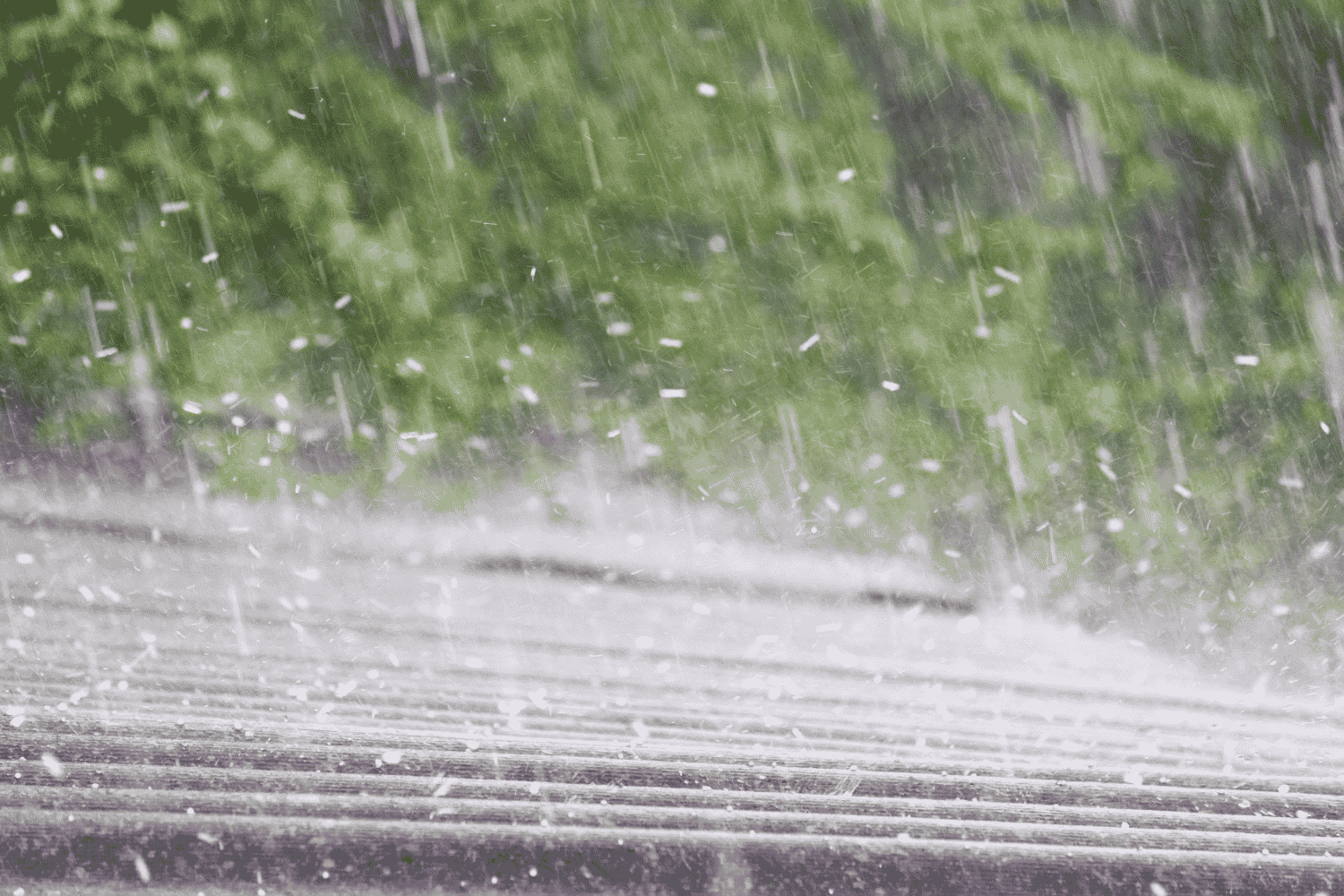 A person documenting hail damage on a roof, preparing to file an insurance claim.