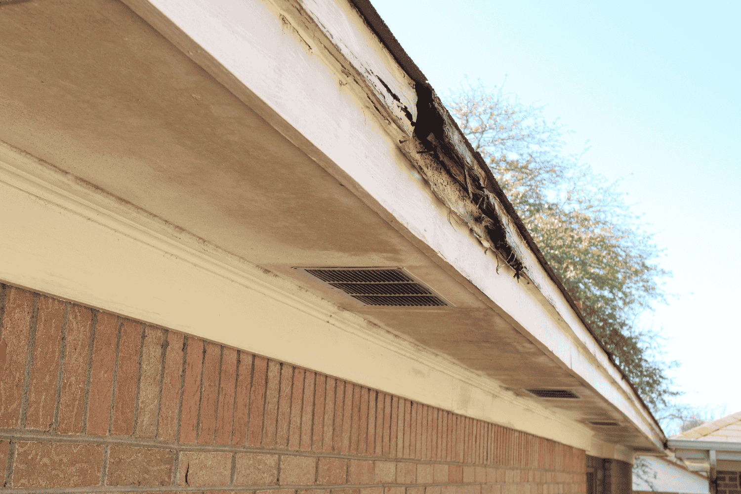 A person removing damaged wood from a structure.