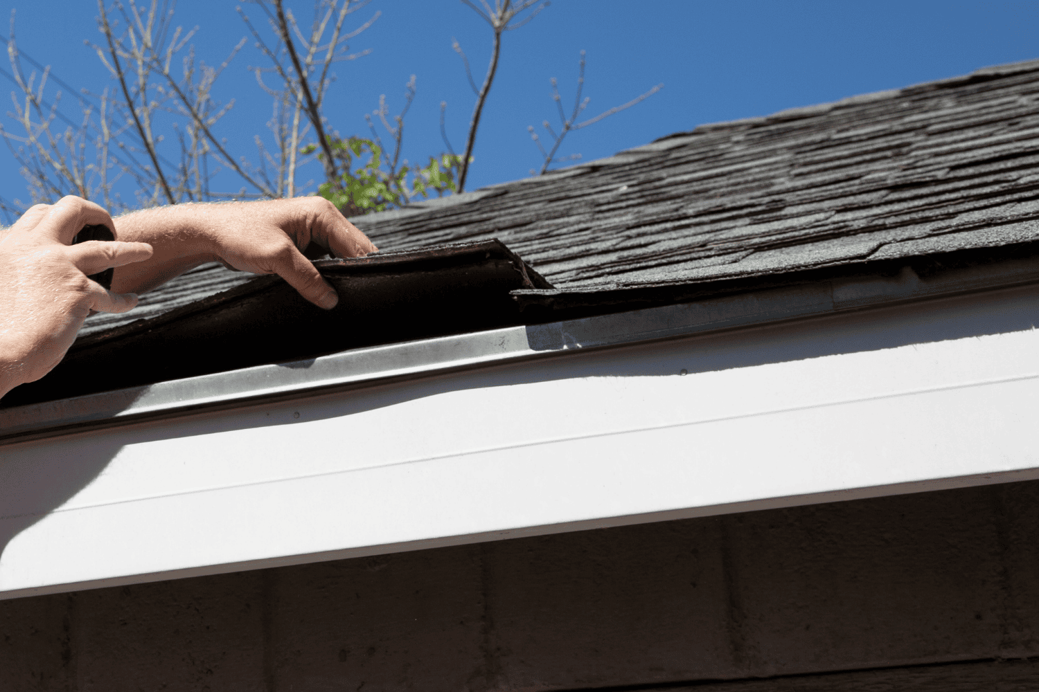 A professional roofer assessing roof damage for repairs.